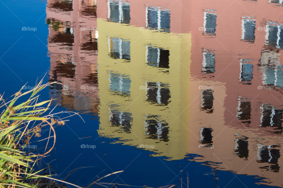 A reflection of a Soviet style apartment building upon a calm lake in Český Krumlov, Czech Republic. 