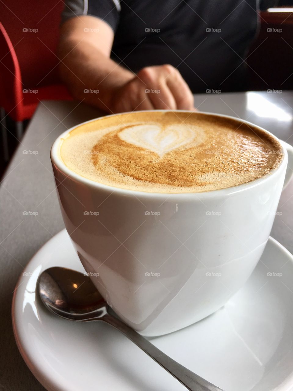 I heart coffee! White heart formed in cup of cafe latte in white mug on table