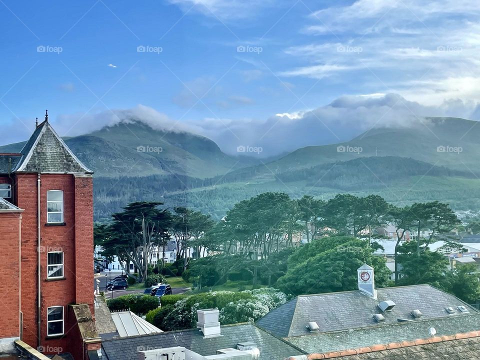 Clouds roll over the peaks of the Mourne Mountains through a window view of the Slieve Donard Hotel.