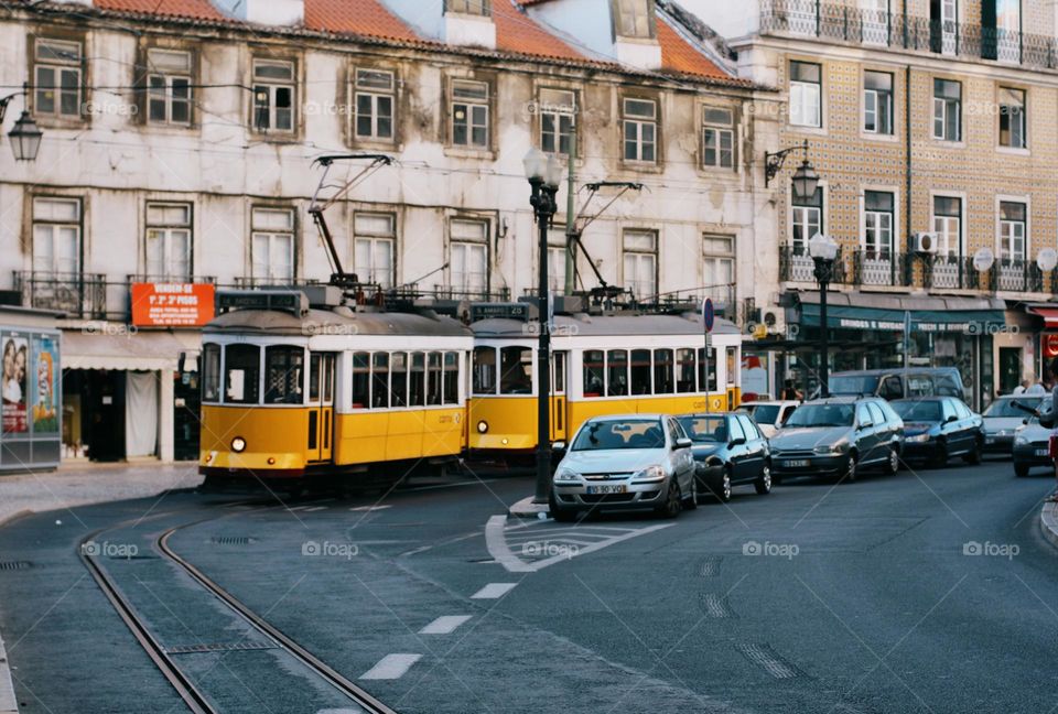 Lisbon street with old historical buildings and yellow trams. Traditional yellow tramp in Lisbon, Portugal, no people.