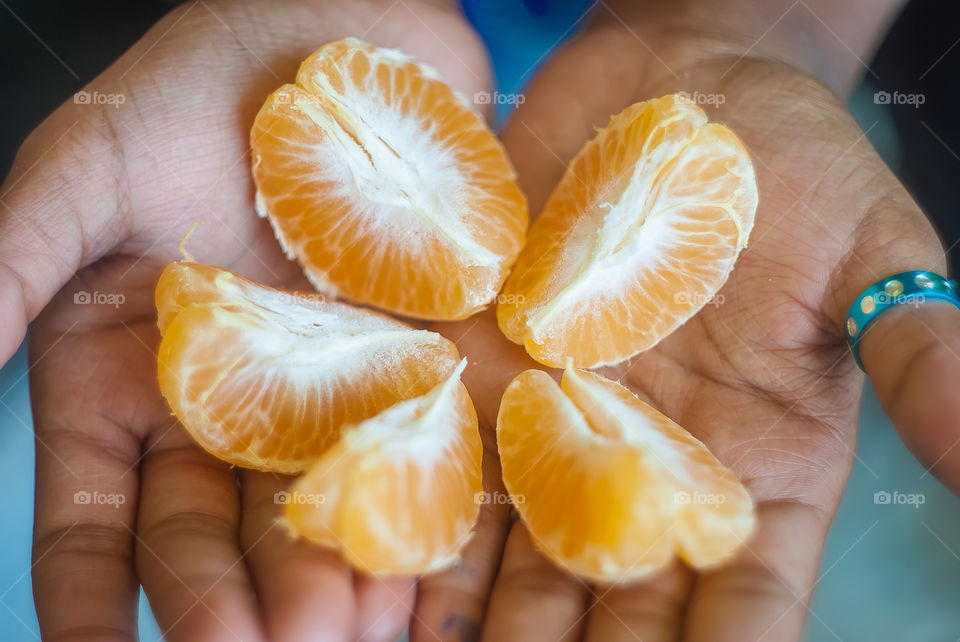 Close-up of hand holding orange