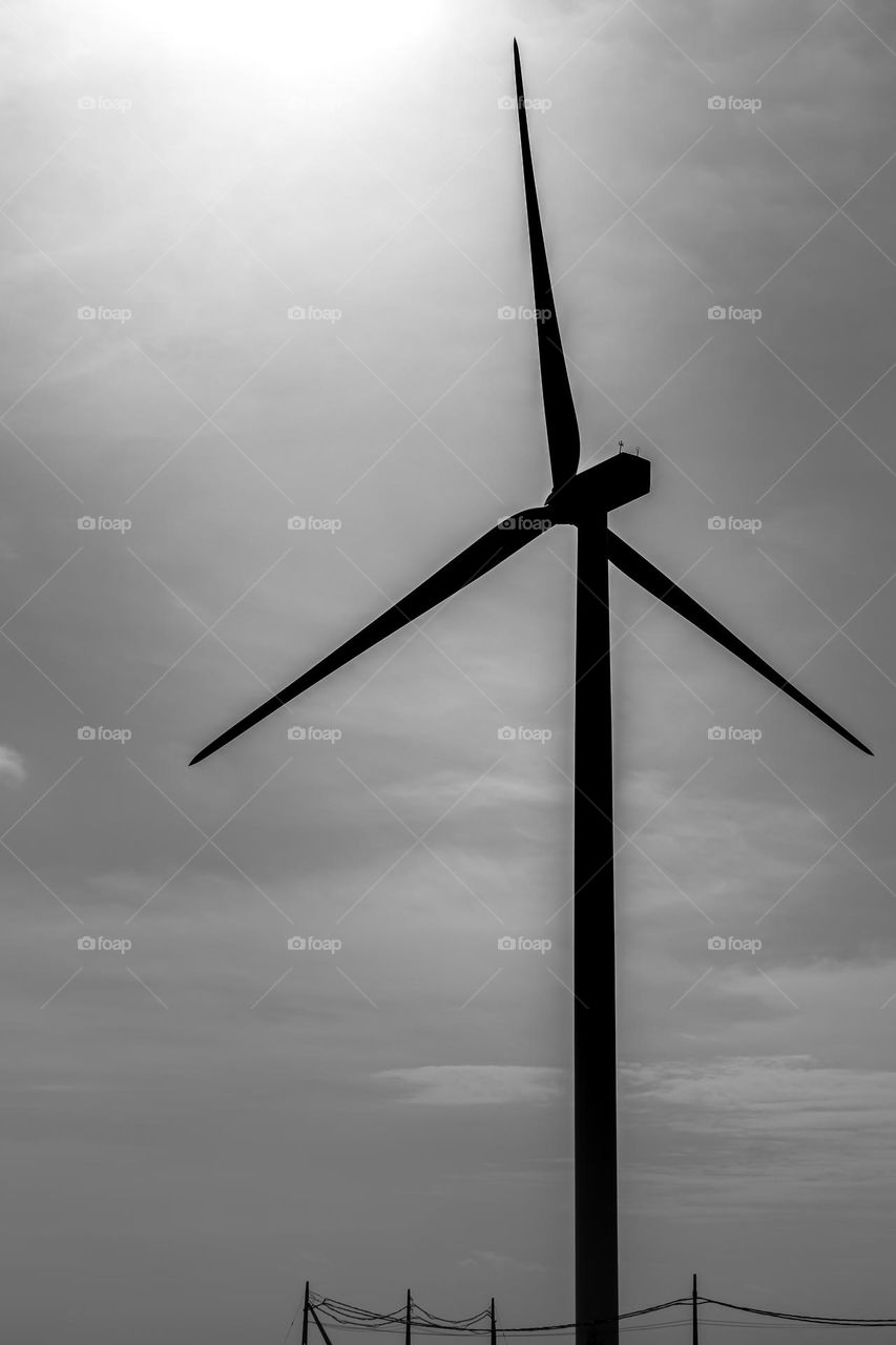 A wind turbine in Jaffna, northern part of Sri Lanka. Black and white vs colours. Cloudy and moody surrounding.