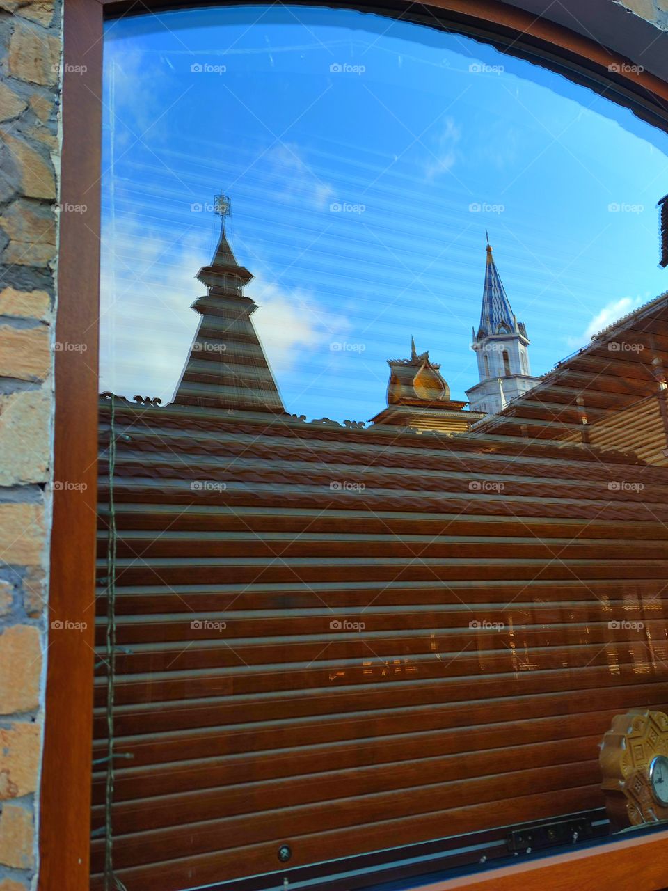 A shop window that reflects the domes of the towers and the blue sky