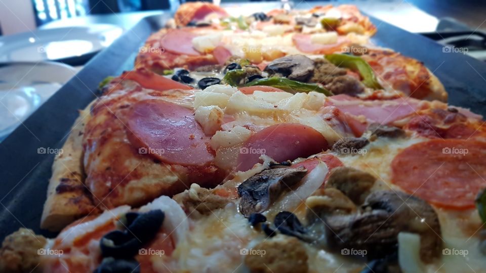 deliciosas rebanadas de pizza Hawaiiana  y Italiana listas para comer