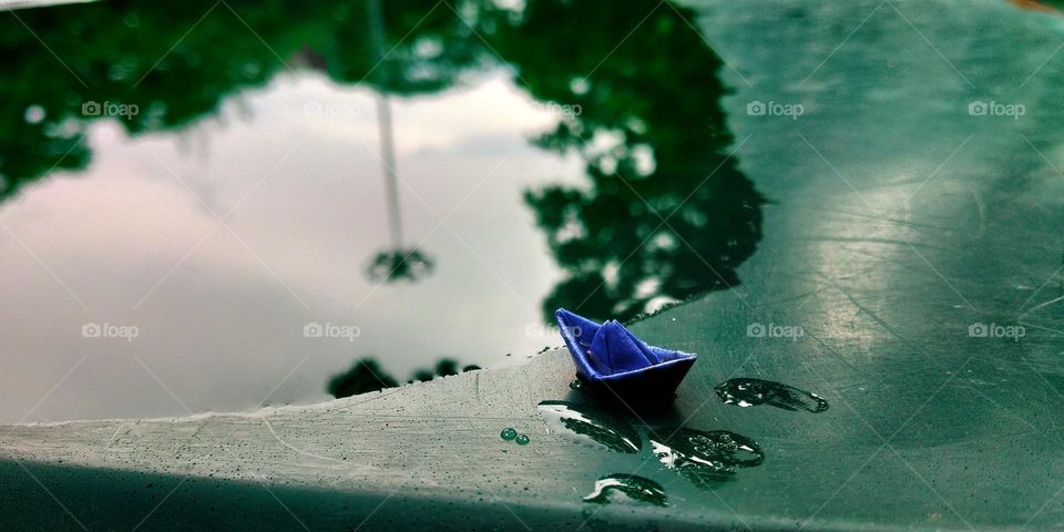 paper boat and water reflecting a street lamp