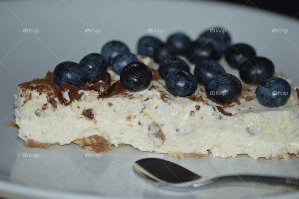 homemade cold cheesecake with grated chocolate and fresh blueberry