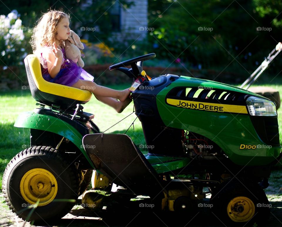 miss John deere. enjoying a relaxing ride on dad's John deere.