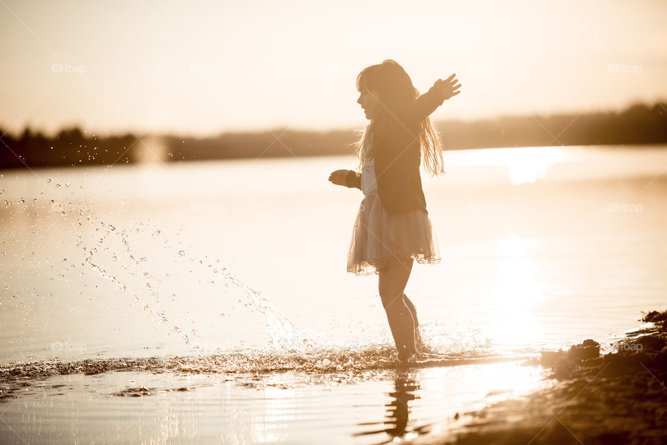 Little girl on lake coast