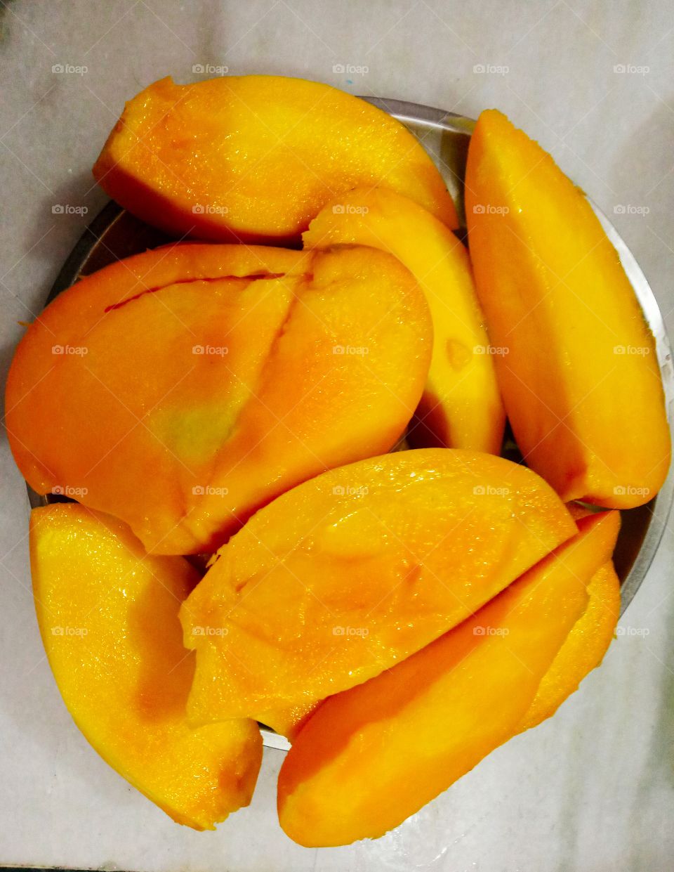 A mango is an edible stone fruit produced by the tropical tree Mangifera indica which is believed to have originated from the region between northwestern Myanmar, Bangladesh, and northeastern India.