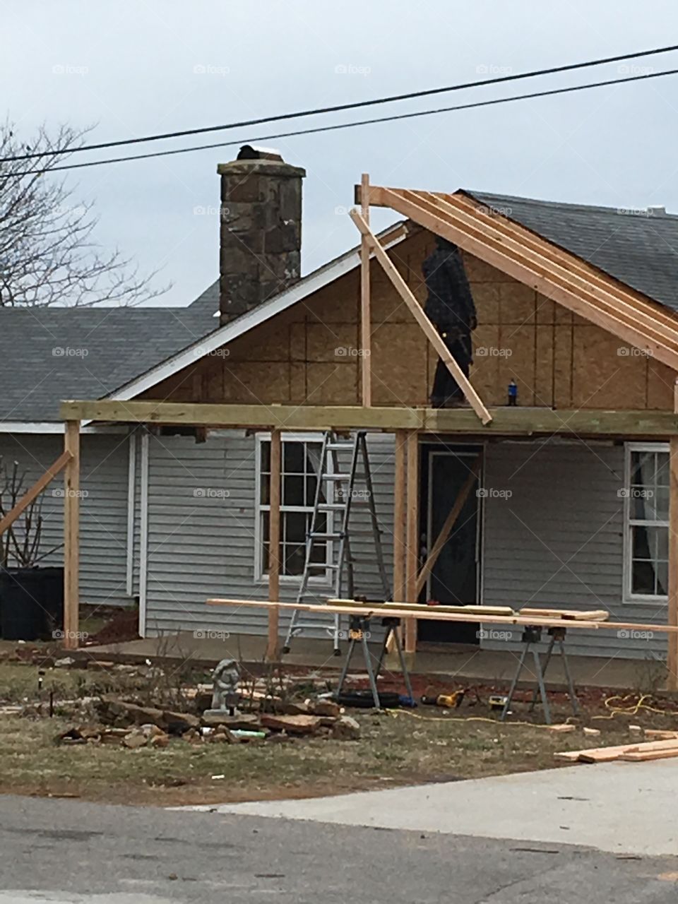 Working hard. Neighbors house is getting a face lift! A new over hang and post! 