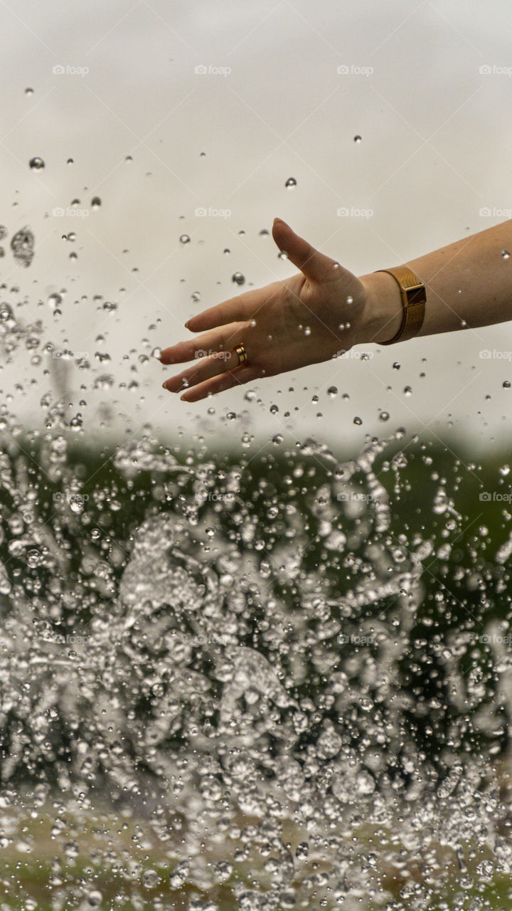 hand under the stream of the fountain