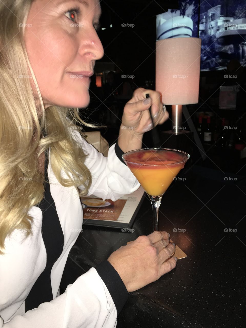 Cocktail hour. Woman Having the famous Bellini at at bar