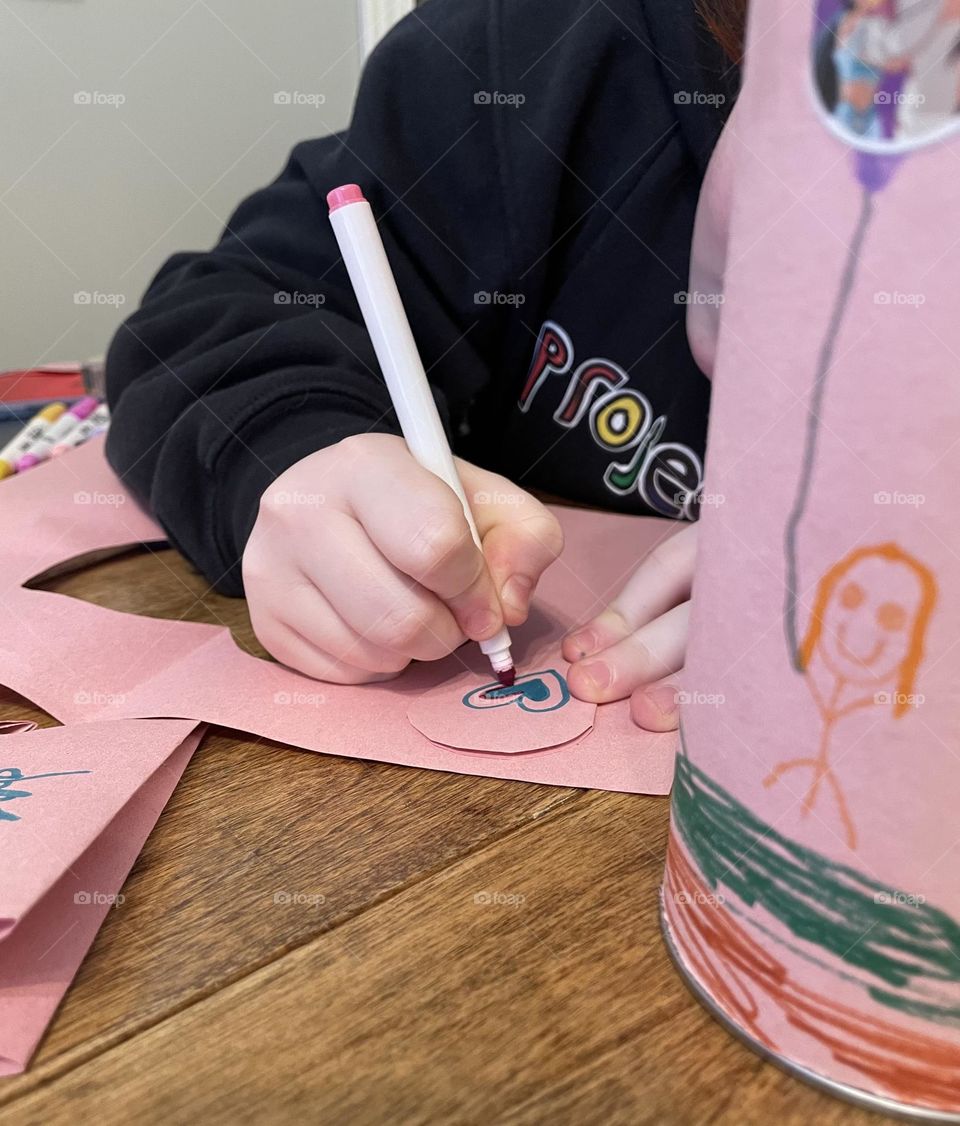 Creating with kids! Homemade Valentine cards, with construction paper, sizzors, felt markers and tape, this 8 year old loves making her own, here she is colouring in her heart that she just cut out, on this cool, snowy, winter day.