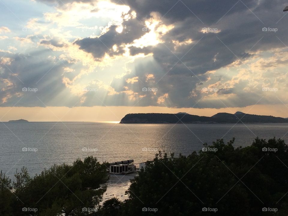 Sun rays across the clouds on the sea