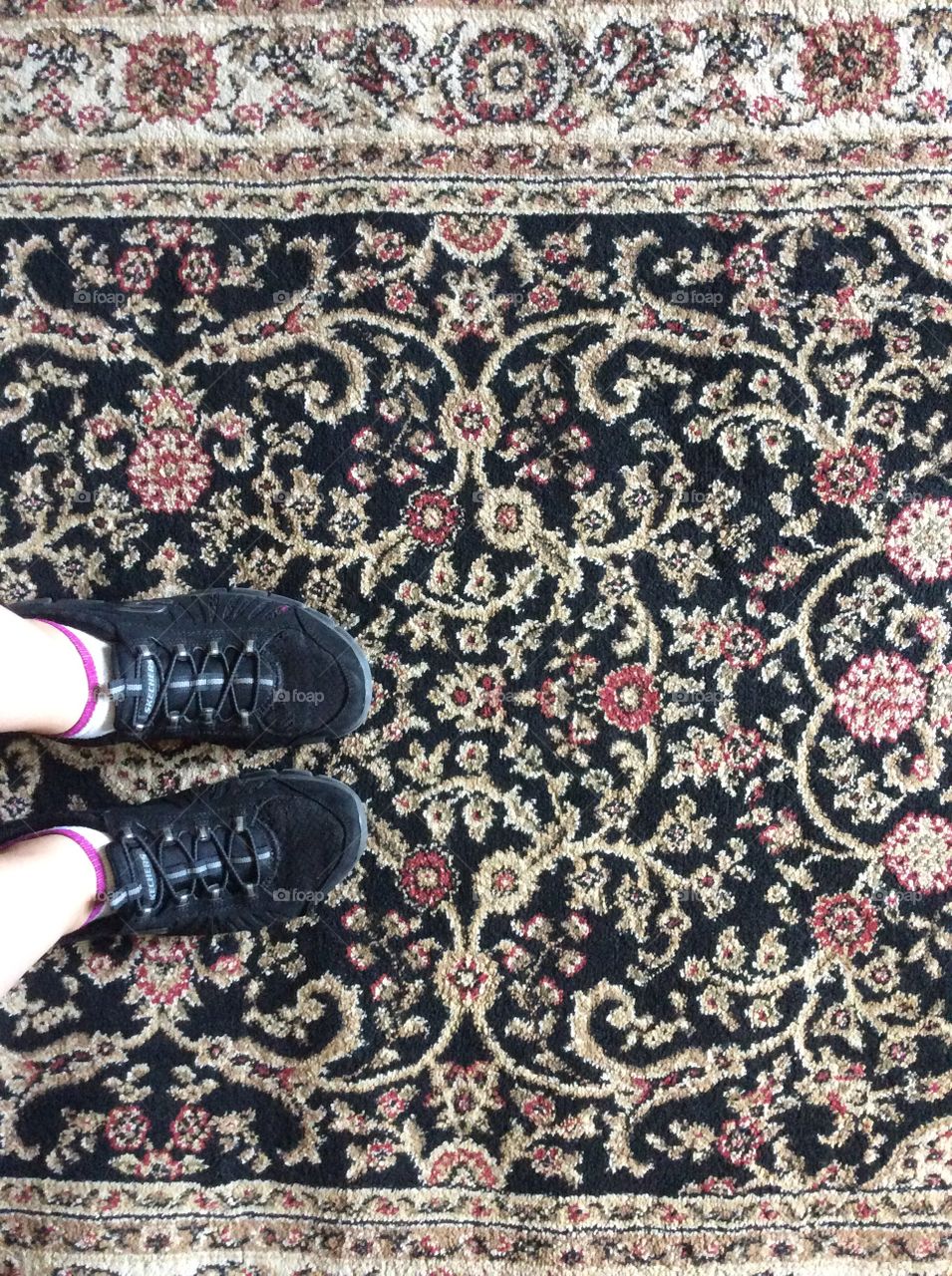 Standing on 1 of many rugs in the work place.