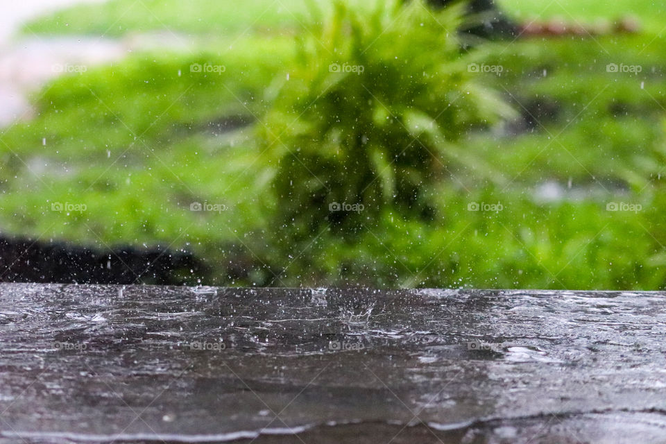 Raindrops splashing on concrete