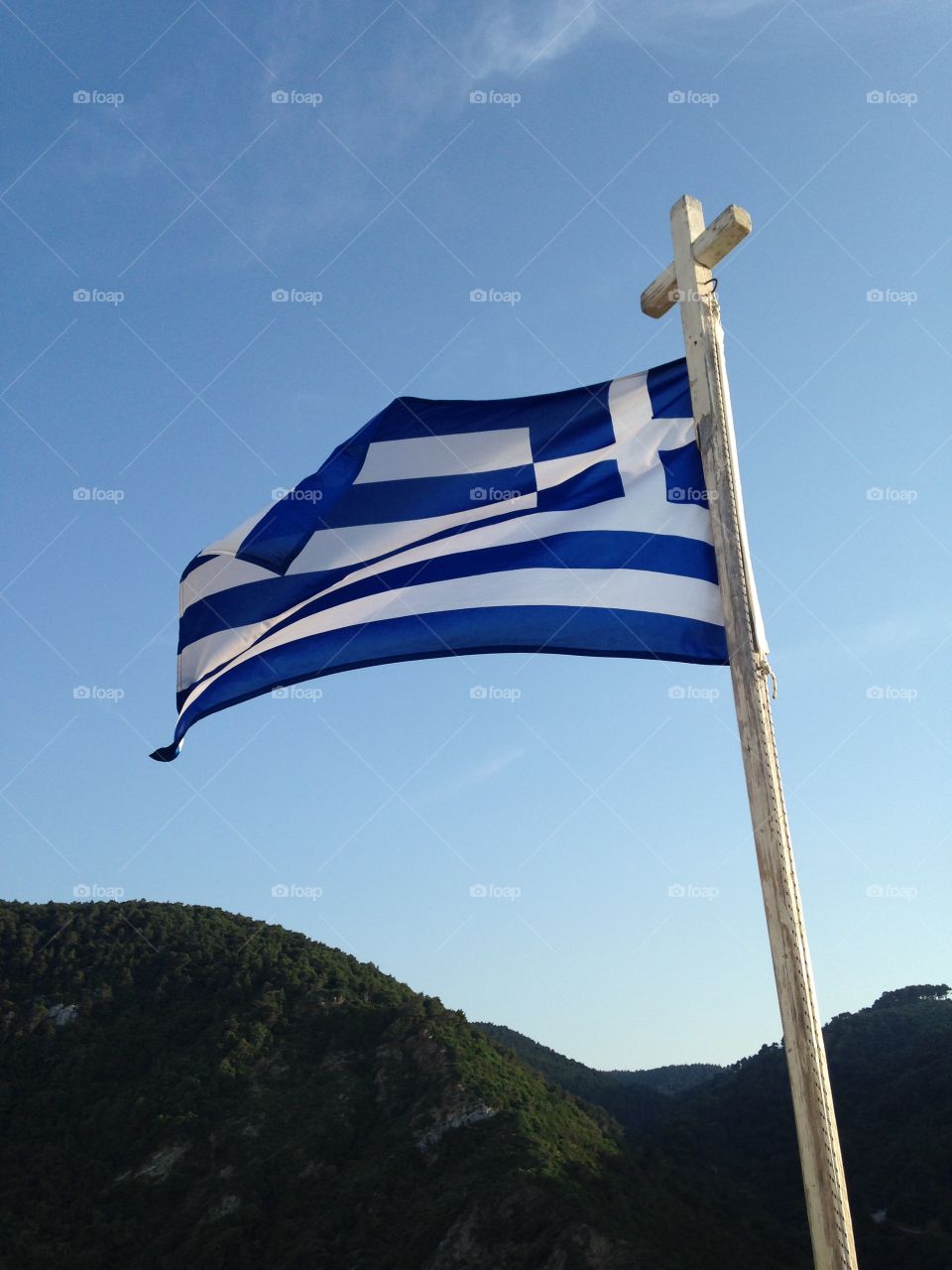 Greek flag. The Greek flag flutters in the sea breeze on the rock next to Agios Ioannis Sto Kastri. Skopelos.