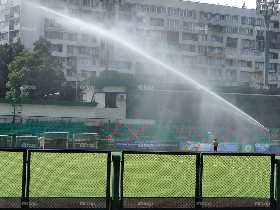 Summer in the city, playground for games, watering the grass.