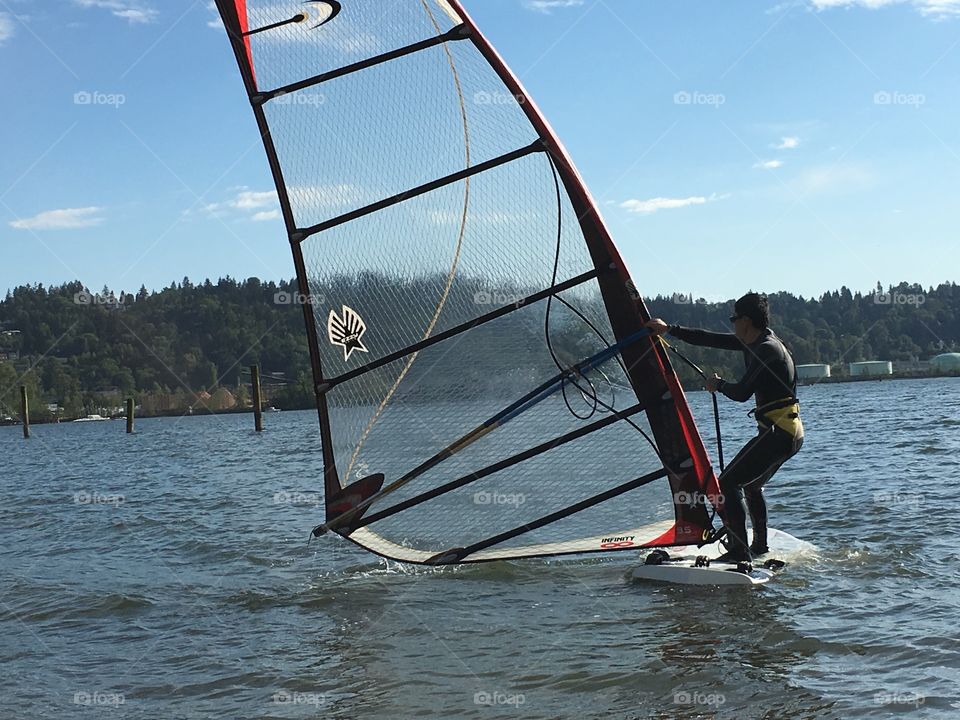 Asian man windsurfing in harbour closeup