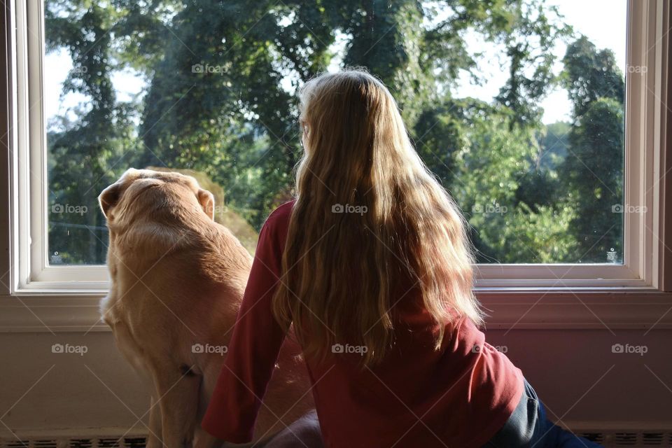 Woman and dog looking through window