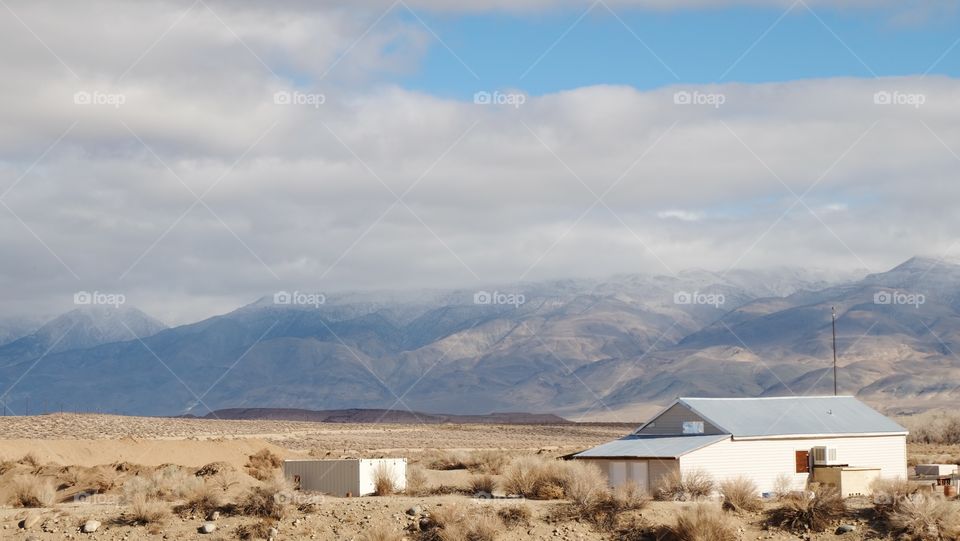 House desert snow mountains. House in a desert valley with lightly dusted mountains