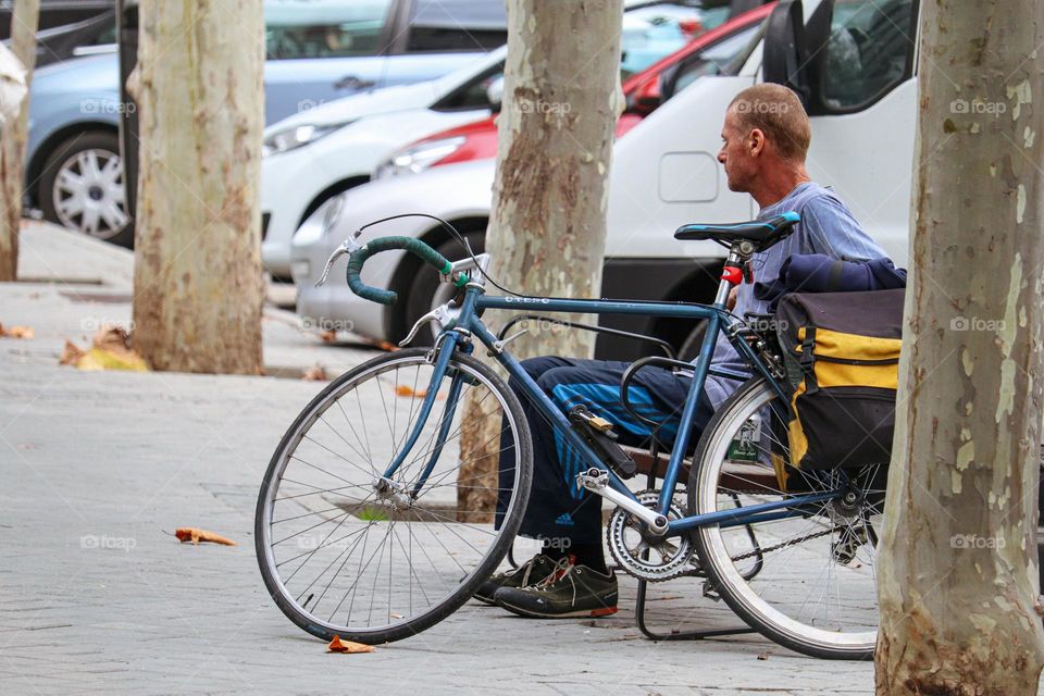 Cyclist taking a break from cycling on a bench