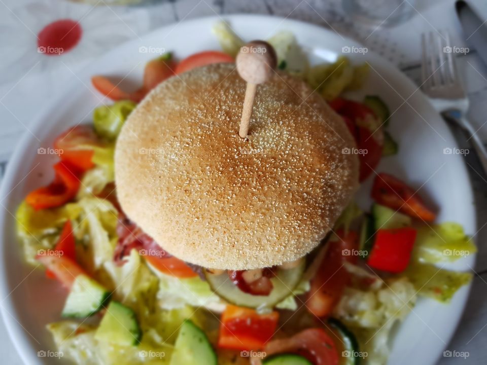 Selfmade burger on a bed of salad