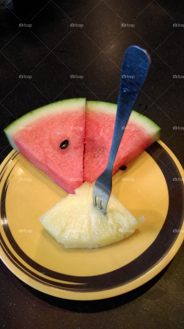 Slice water-melon and pineapple on the yellow dish