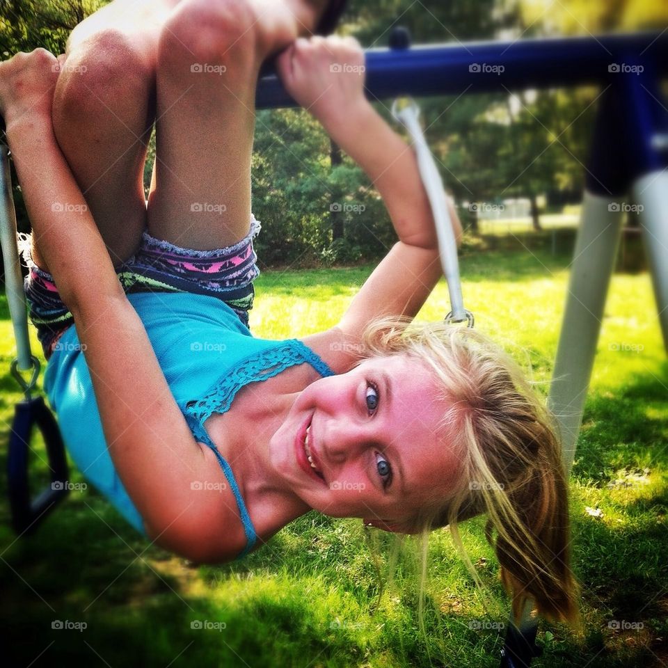 Silly little girl hanging upside down.