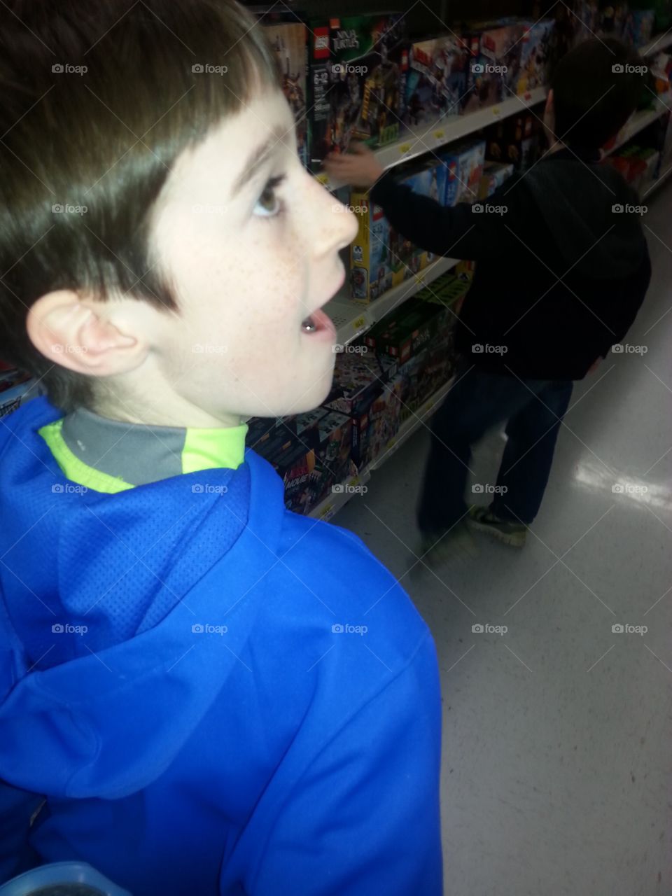 Young boy looking in the store aisle in wonderment.