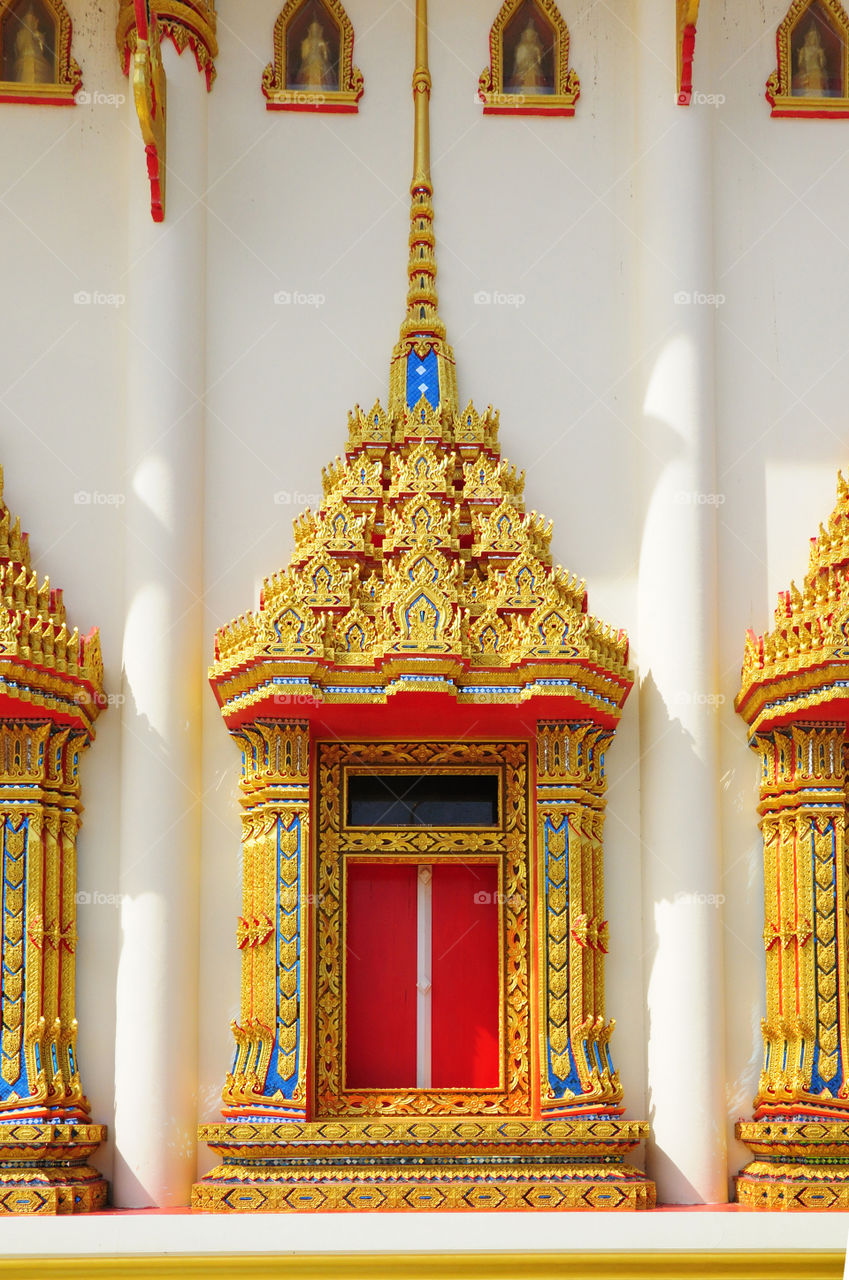 Church window caved Thai motifs beautifully. Pan Thai Nor Ra Sing temple, Thailand.