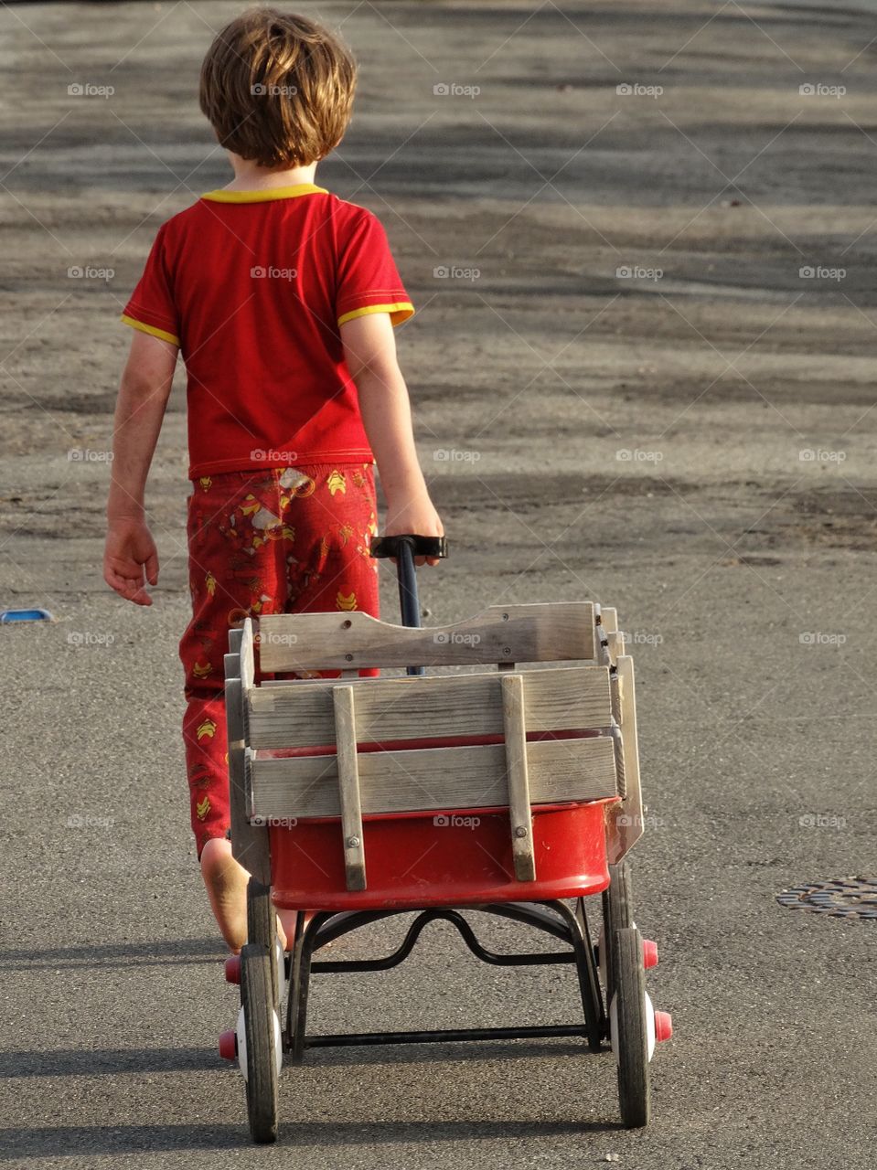 Boy Pulling A Wagon. Little Boy Pulling His Red Wagon Down The Street
