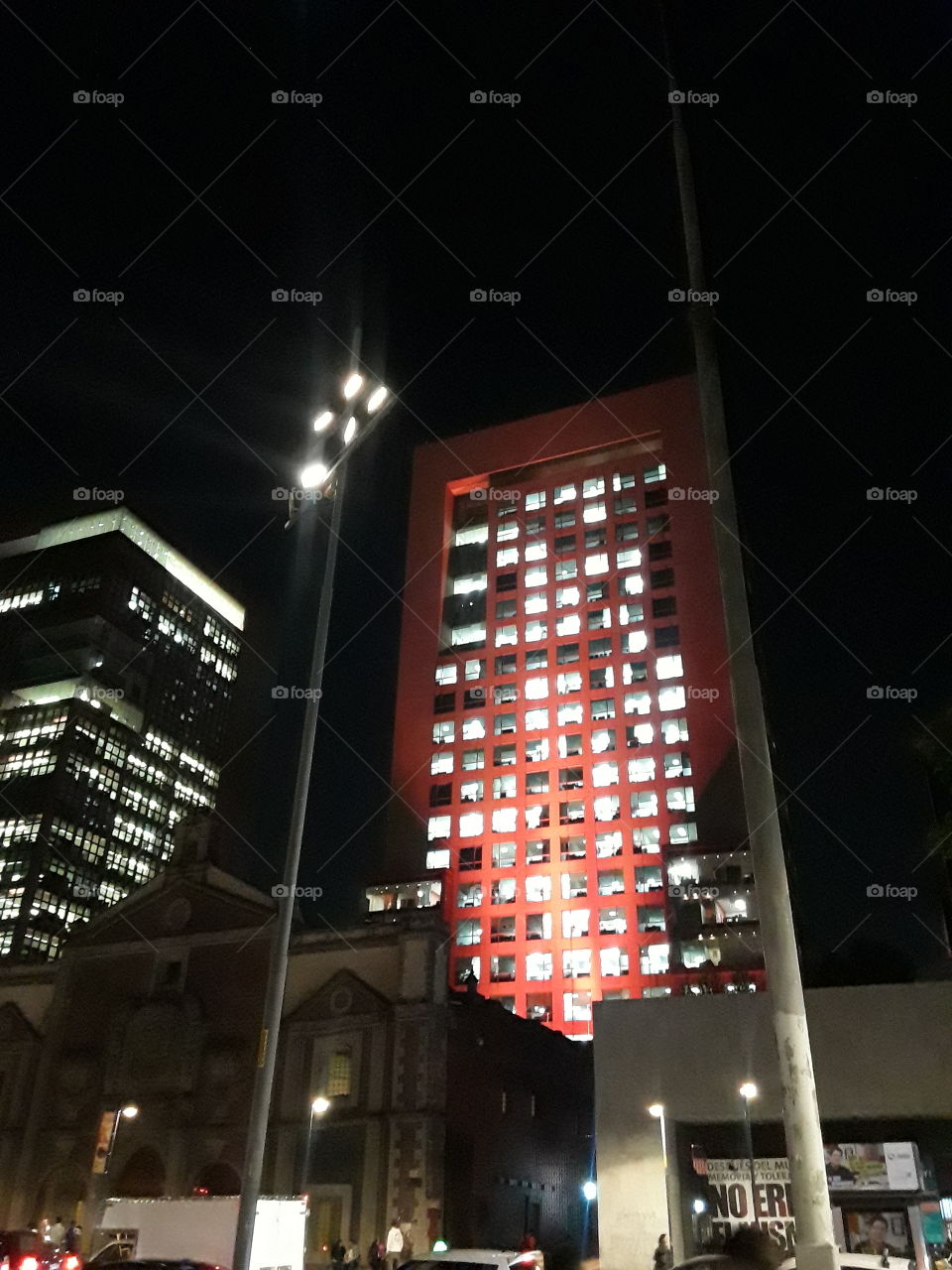 torre de edificios en la ciudad... con luces de color  rojo.  nocturno