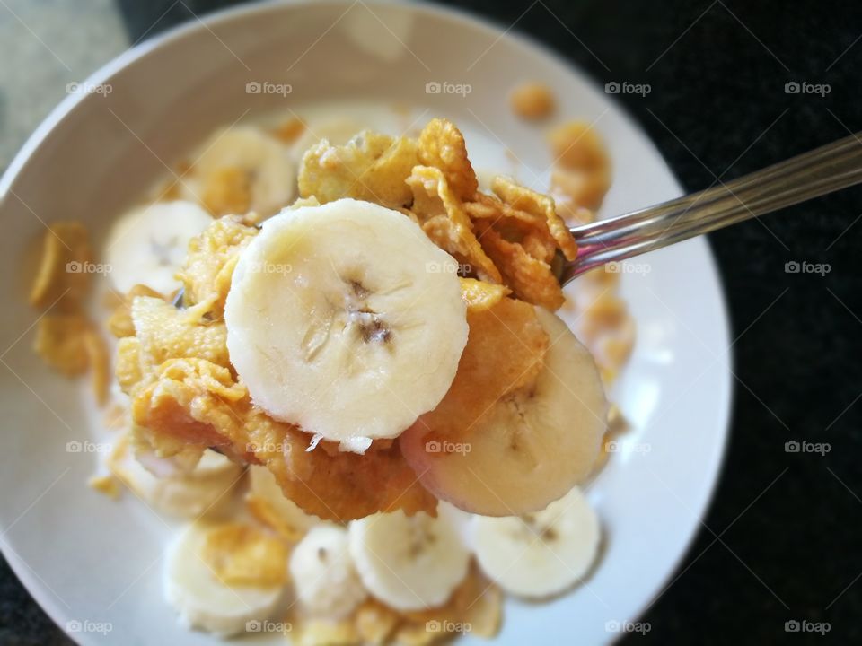 Cornflakes and banana with milk for breakfast.  Healthy food.  Cereal and banana with milk.