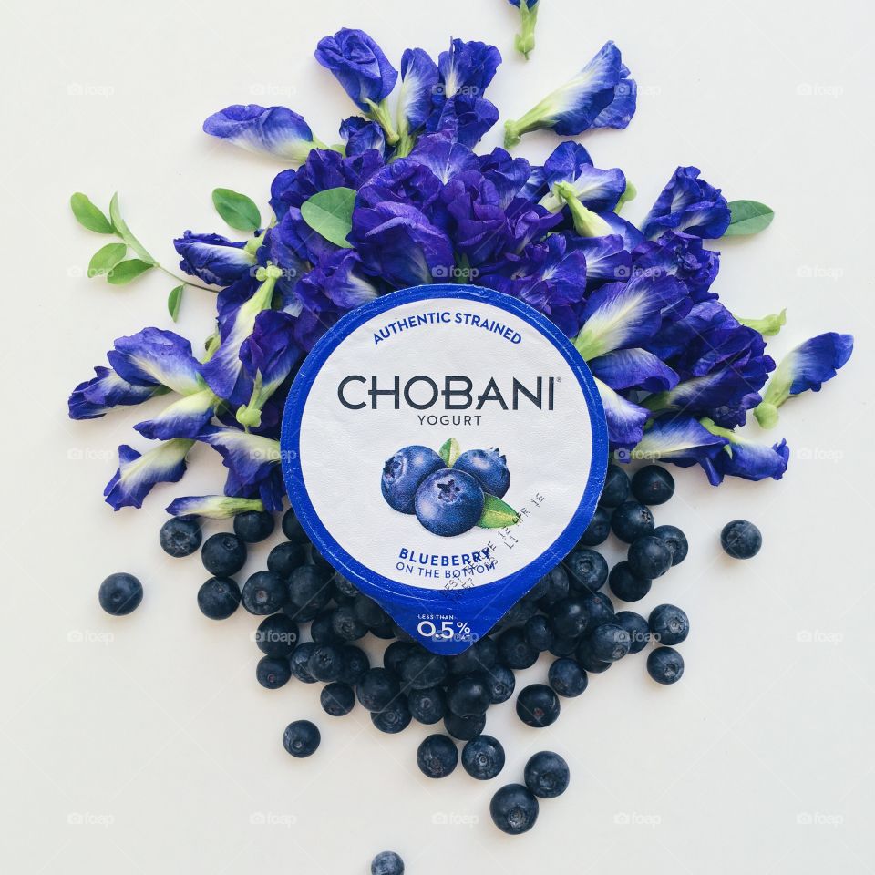 CHOBANI Flat Lays : Chobani Blueberry with blueberries and blue butterfly pea flowers.