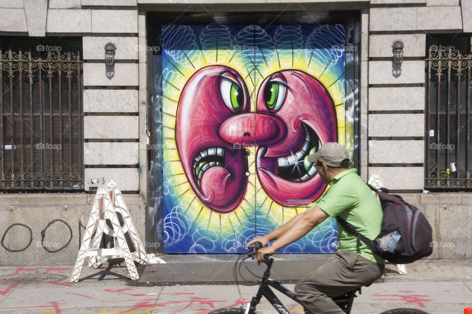A bicyclist observing the street art in Manhattan, New York City, during the annual celebration of public space, 7 miles of streets are open to the public space for play, run, walk and bike.