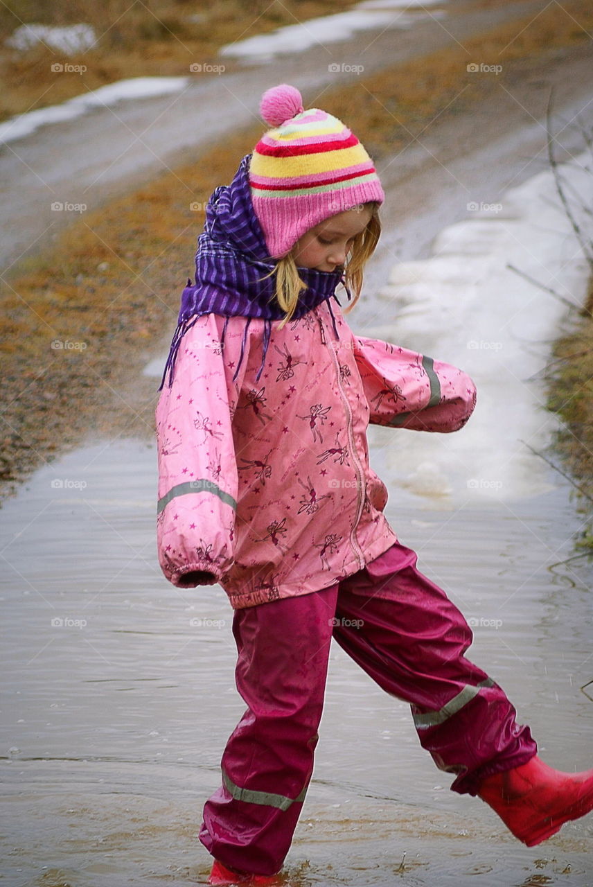 Girl playing in a waterpuddle