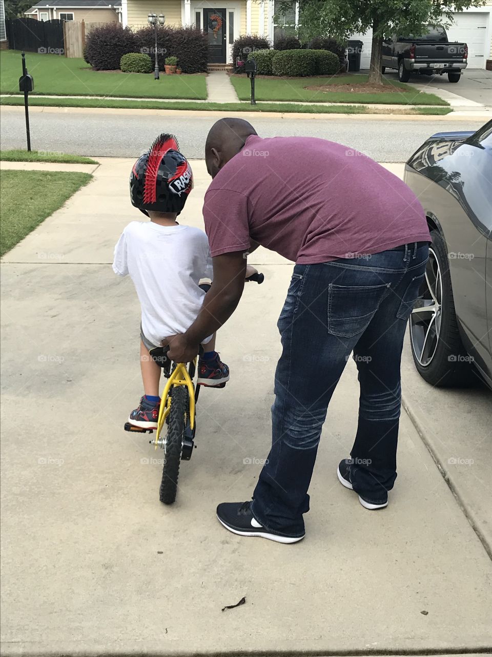 Teaching young boy to ride his bike without training wheels