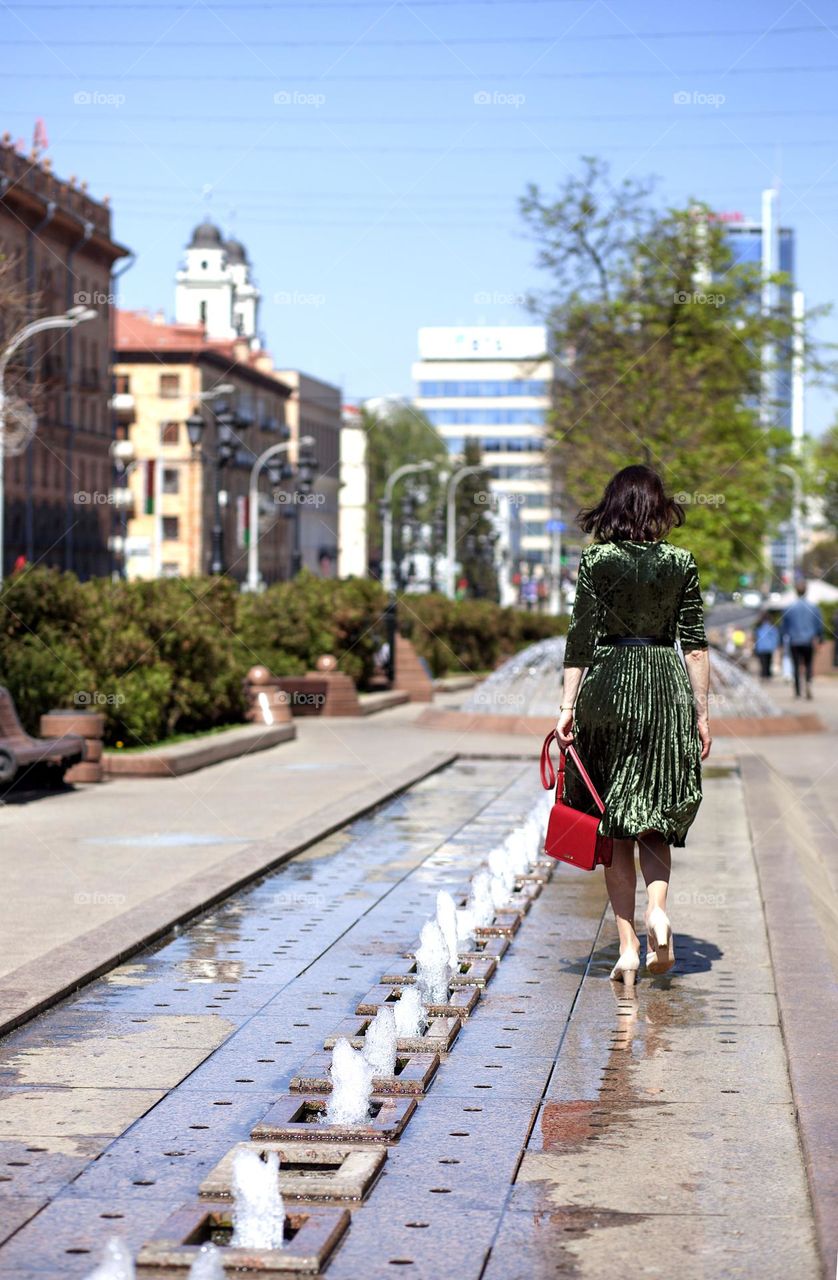 fountains-decoration and comfort of the city, a woman walking through the city.