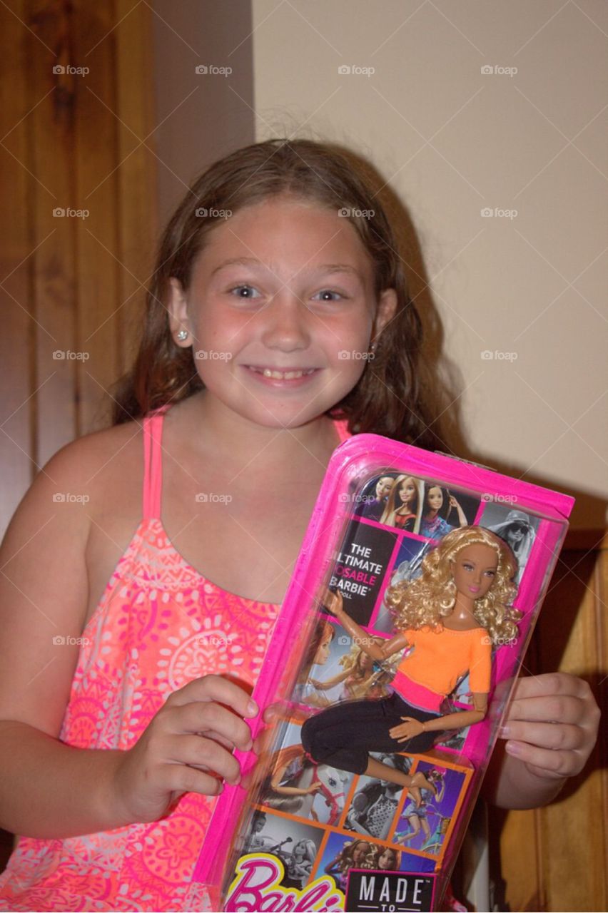 Portrait of a smiling girl holding barbie doll