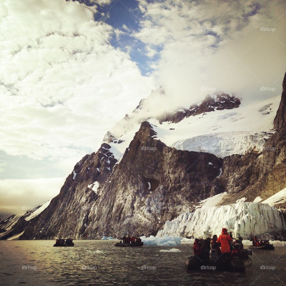 Zodiacs cruising along ice in Svalbard, Norway.