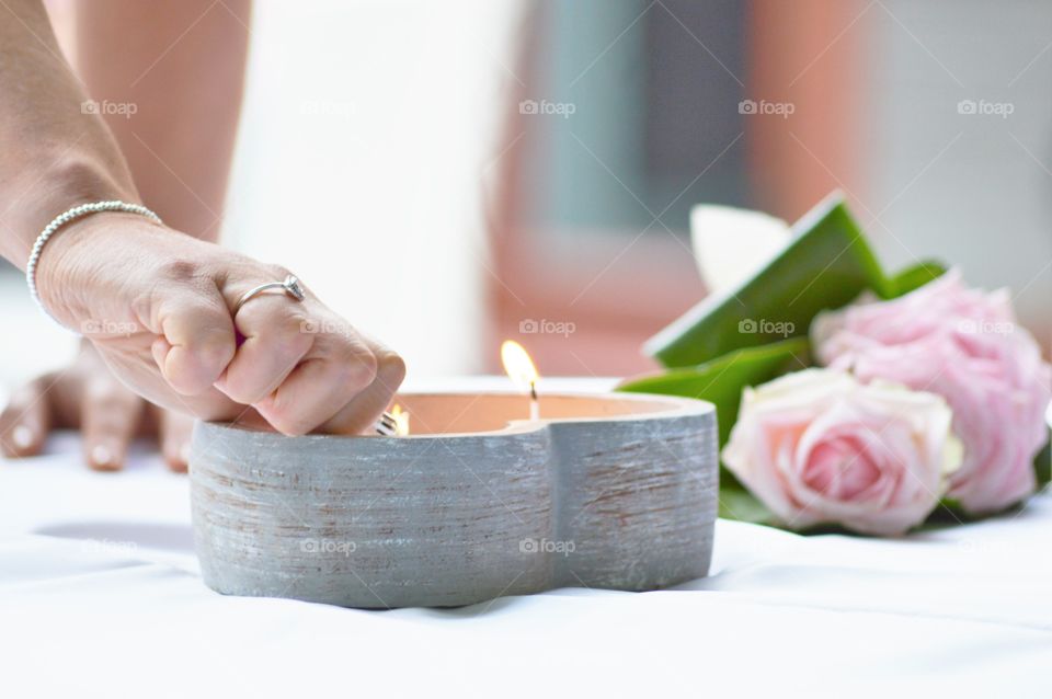 Close-up of women lighting candle