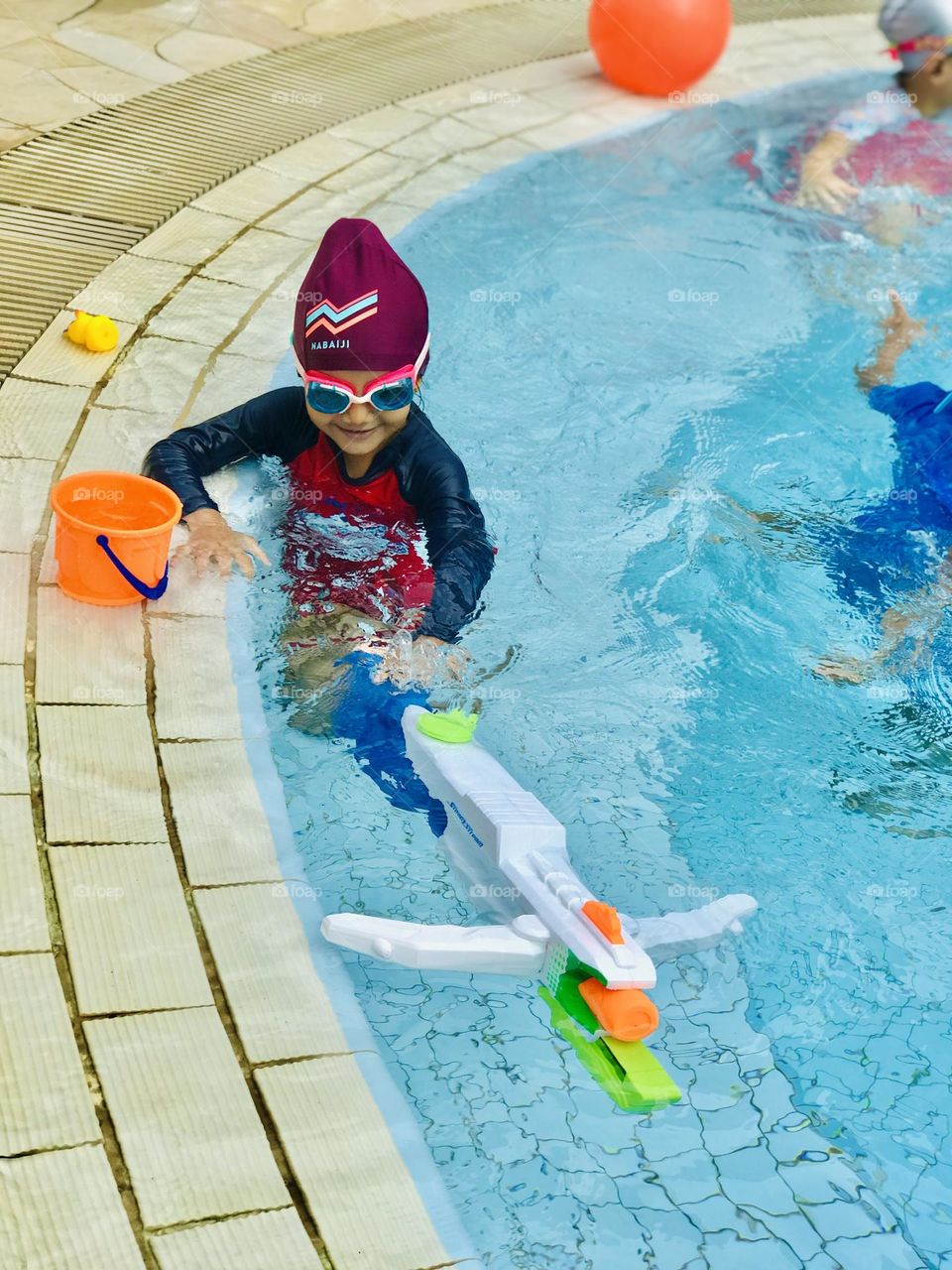 Baby enjoying and playing at swimming pool.