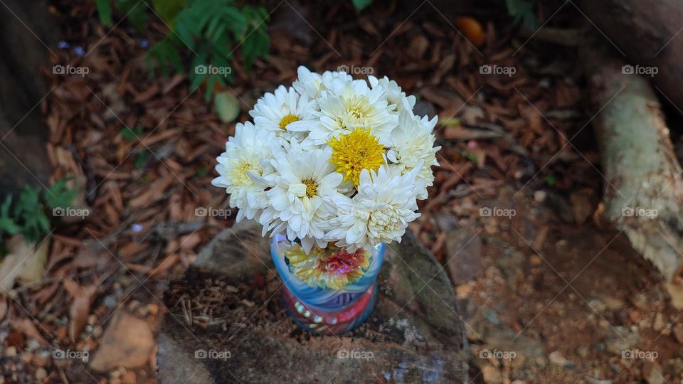 Beautiful white flowers in a colourful flowerpot with a flower sculpture, Flowers in a vase, colourful vase, white flowers in a vase