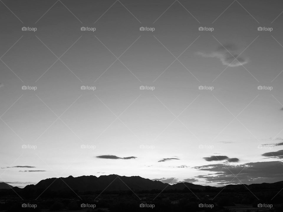 A black and white photo of mountains and clouds