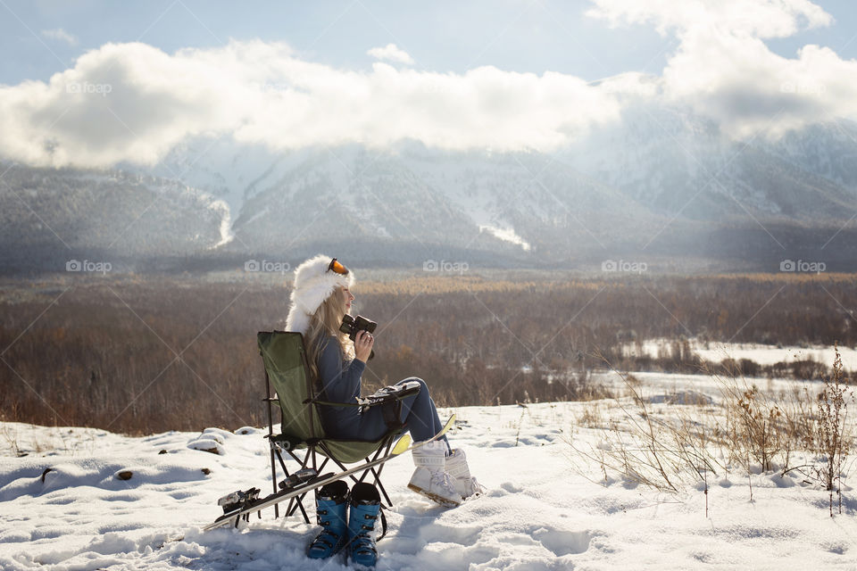 Woman sitting on chair holding binocular