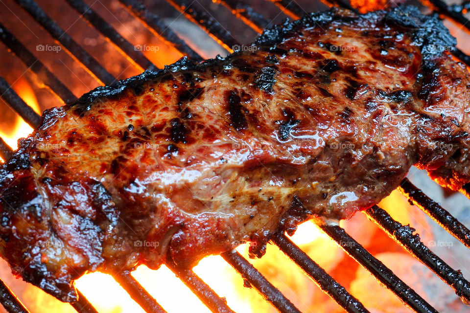 Juicy Steak on the Grill With Fire Flaming Below