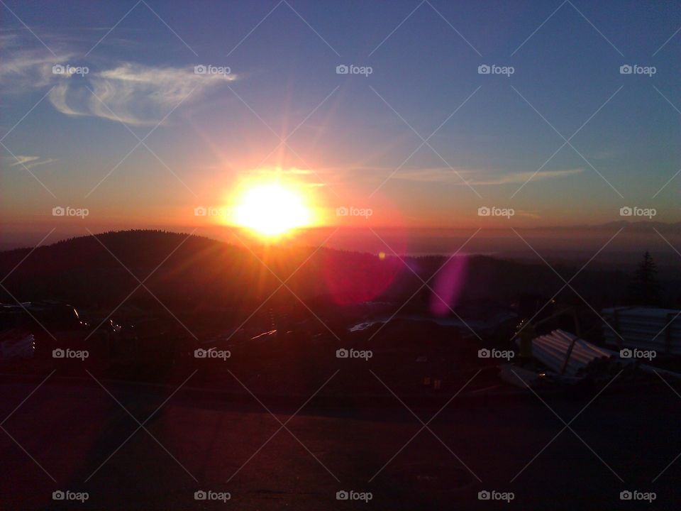 Sunset overlooking a construction site on a hill.