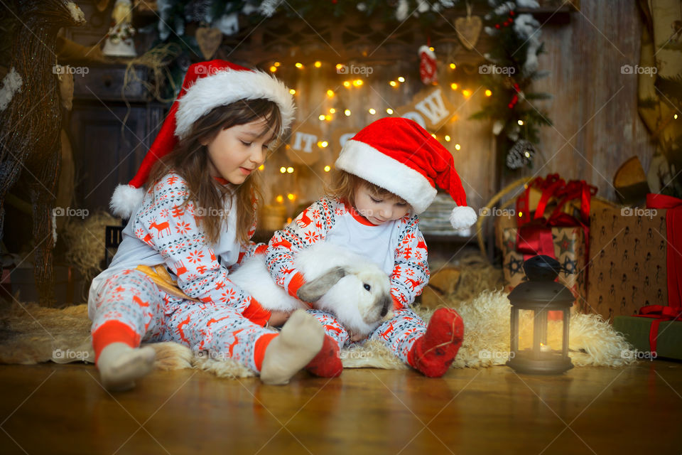 Little sisters near fireplace at Christmas Eve 