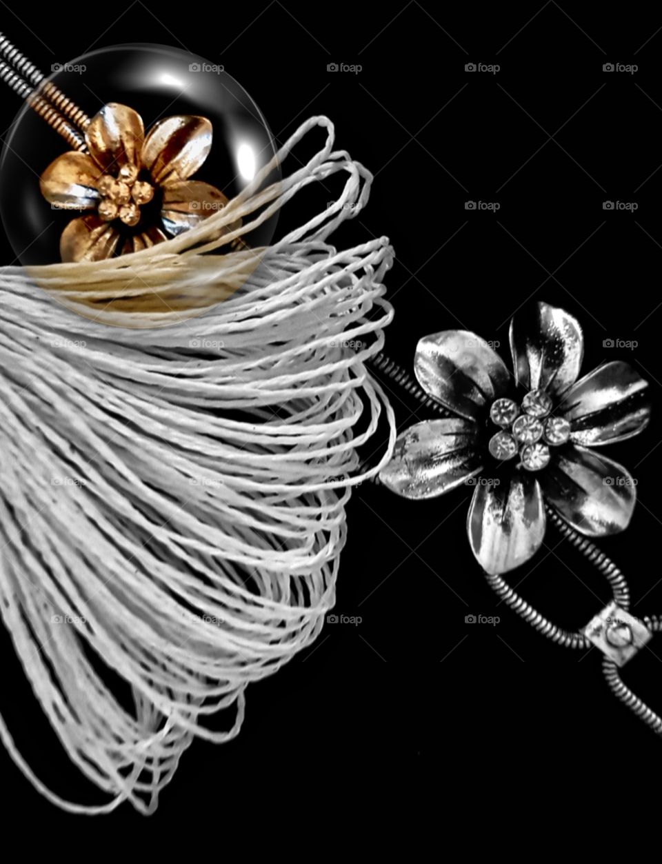 A creation using a silver necklace and string ends and a single bubble reveals color.